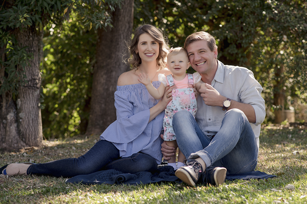 Foto de bebe em caxias do sul fotografa morgana perini pais com filha abraçados grama arvores