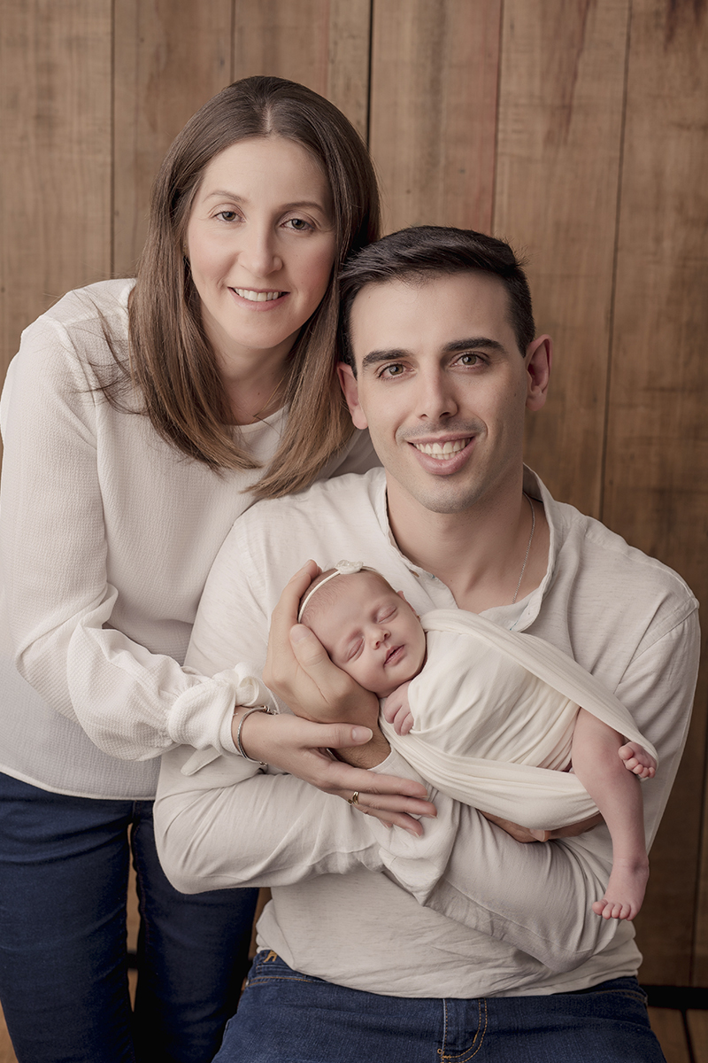 Foto newborn em caxias do sul fotografa morgana perini pai segurando bebe mao abraçando os dois
