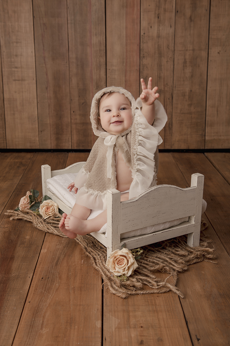 Foto de bebe em caxias do sul fotografa morgana perini bebe com capa sentada caminha branca