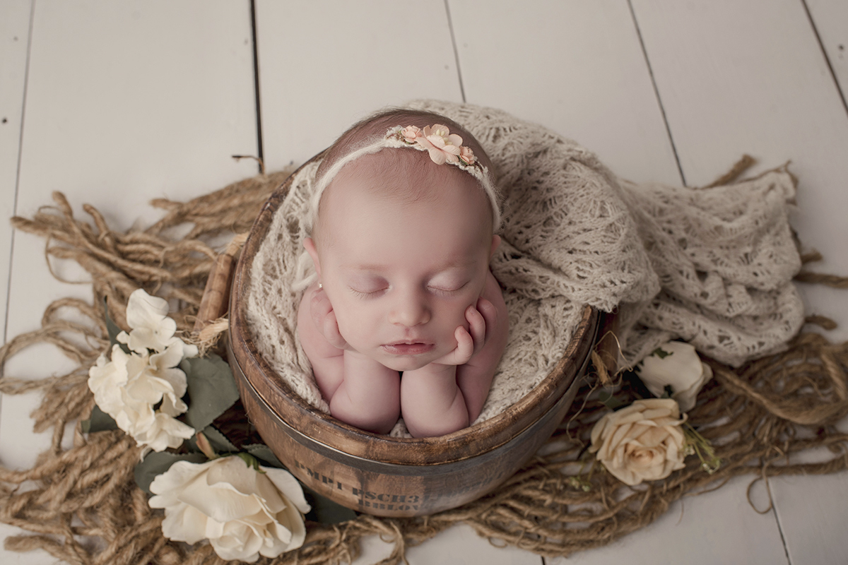 Foto newborn em caxias do sul fotografa morgana perini bebe segurando quixo