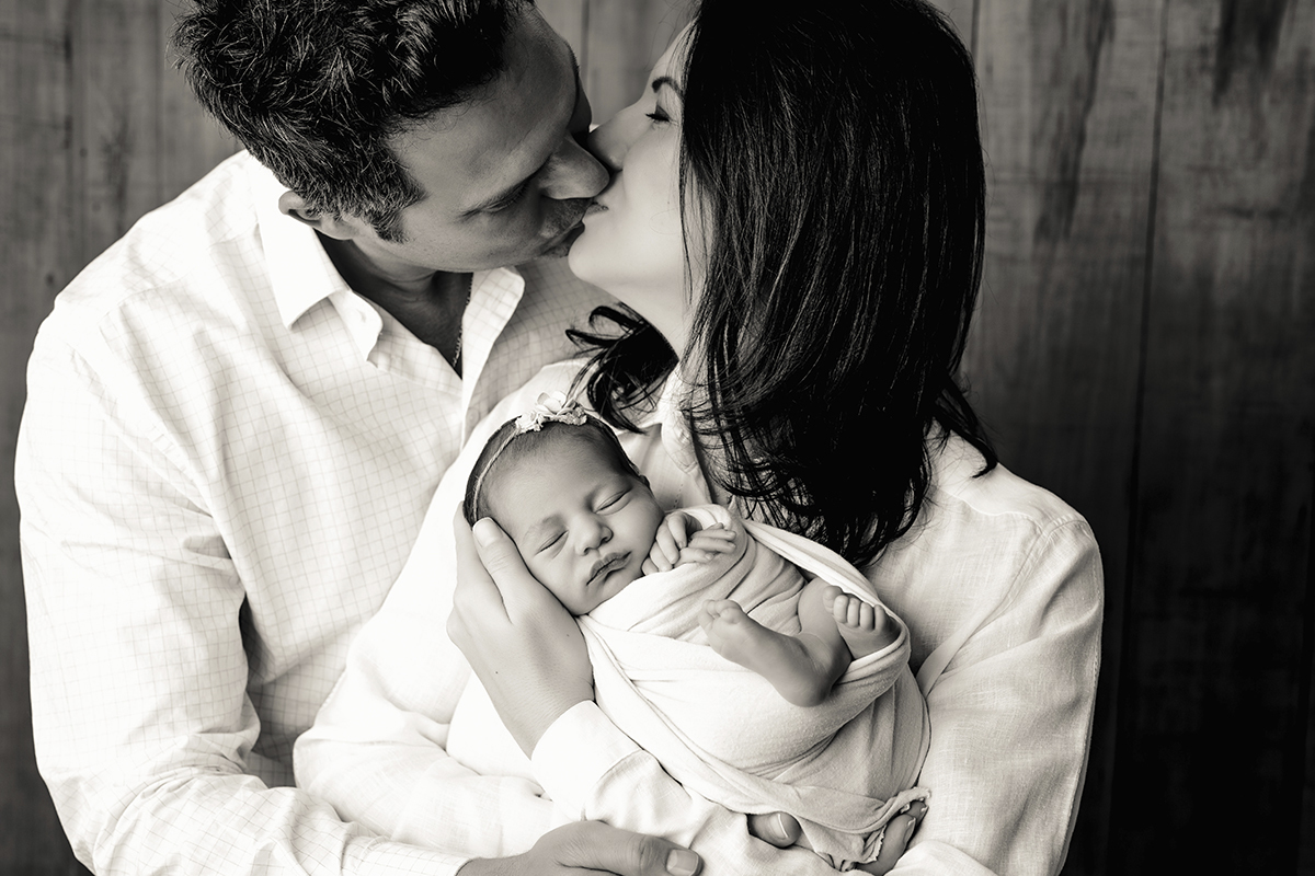 Foto newborn em caxias do sul fotografa morgana perini pais se beijando foto preto e branco