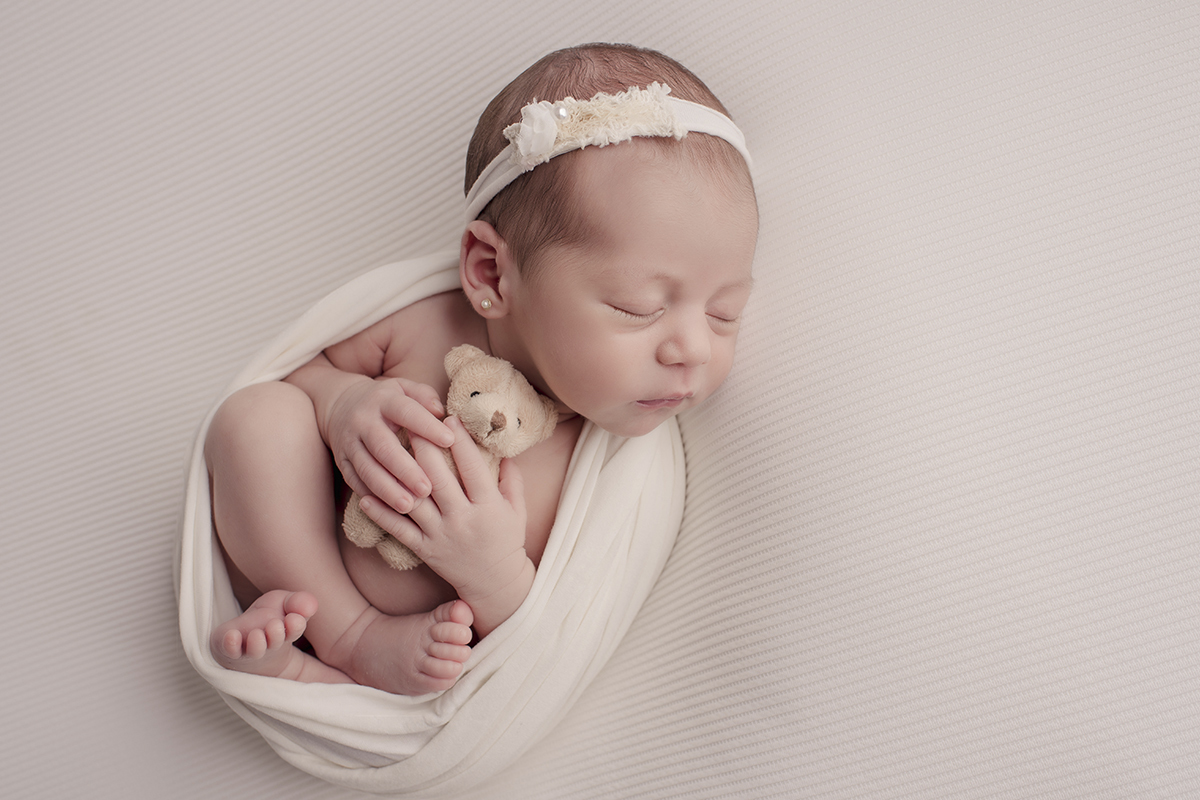 Foto newborn em caxias do sul fotografa morgana perini menina com ursinho tons claros