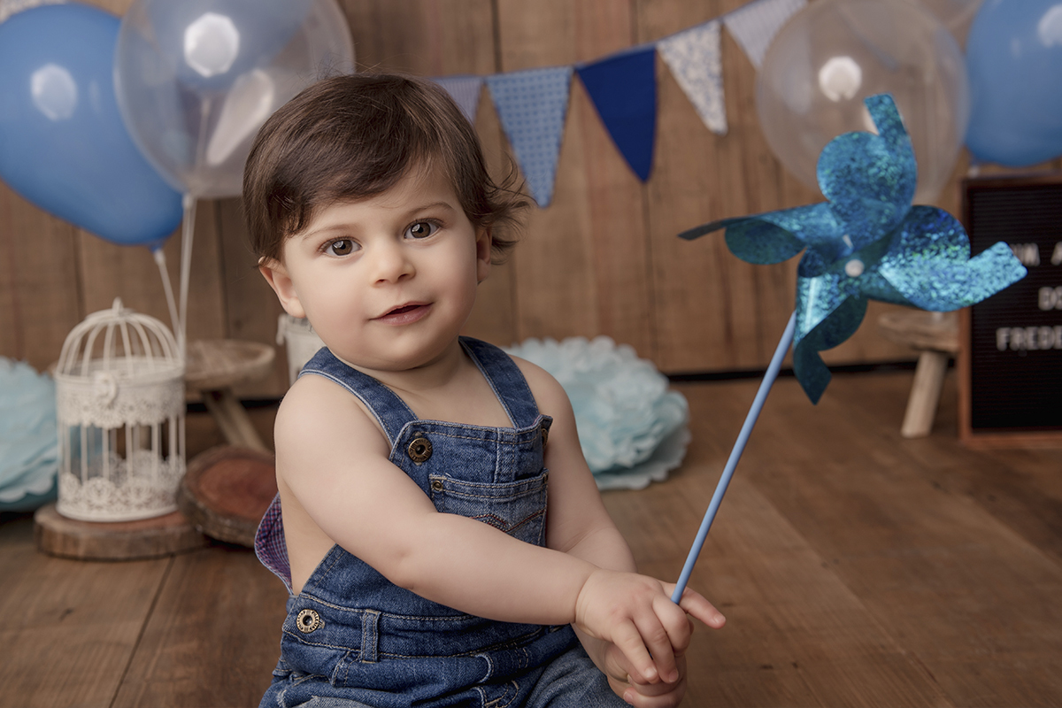 Foto de bebe em caxias do sul fotografa morgana perini bebe com catavento azul e macacão