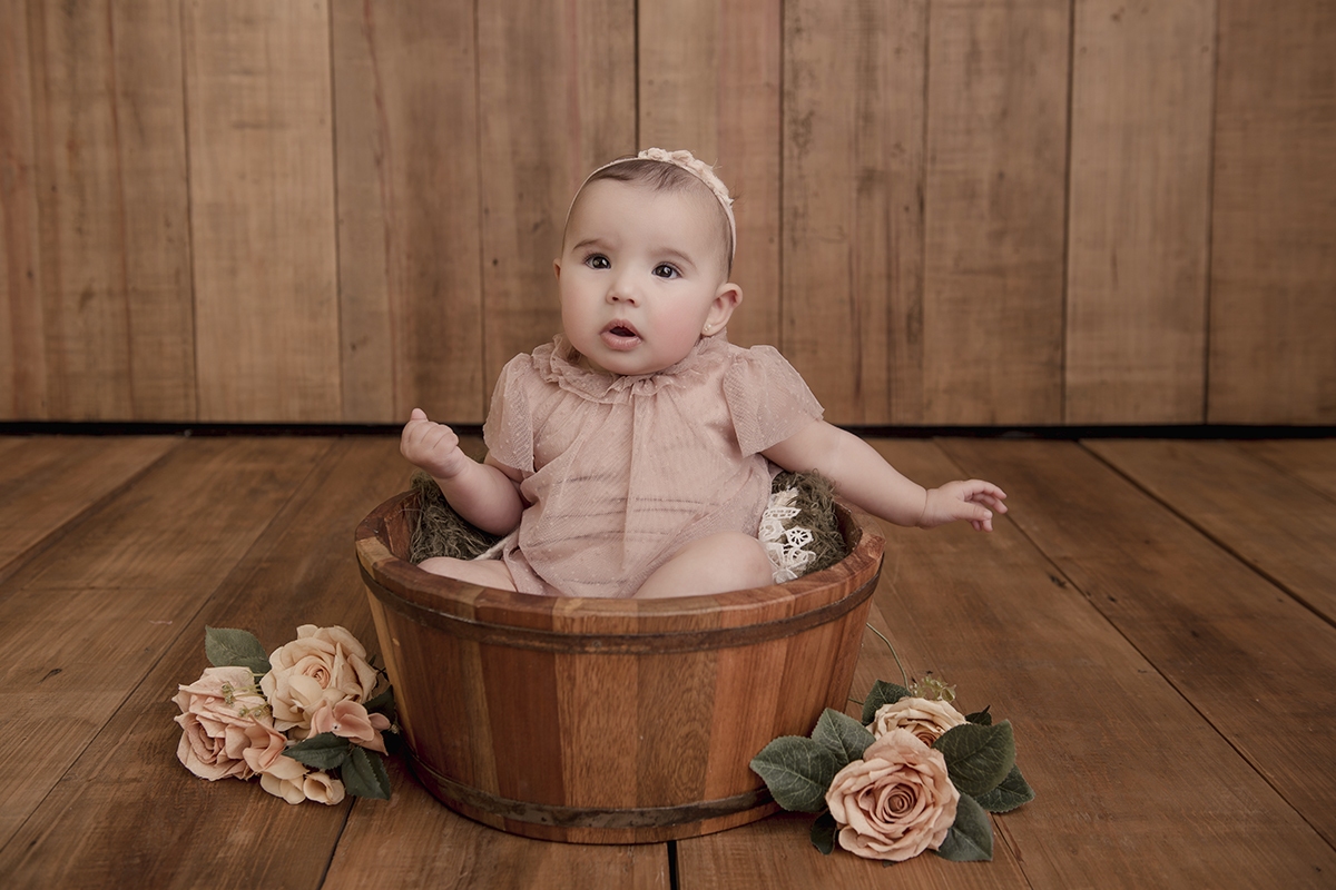 Foto de bebe em caxias do sul fotografa morgana perini menina com flores e barril de madeira