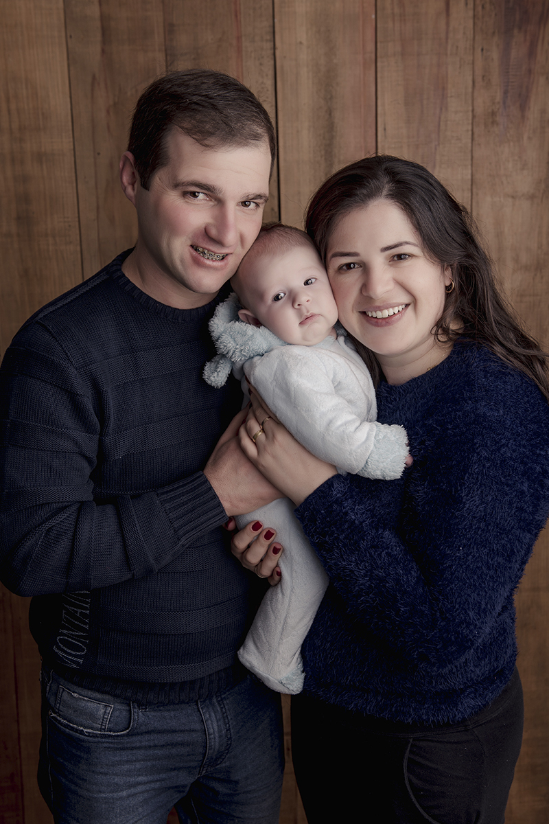 Foto de bebe em caxias do sul fotografa morgana perini pais de blusa azul com bebe com roupa de urso cinza
