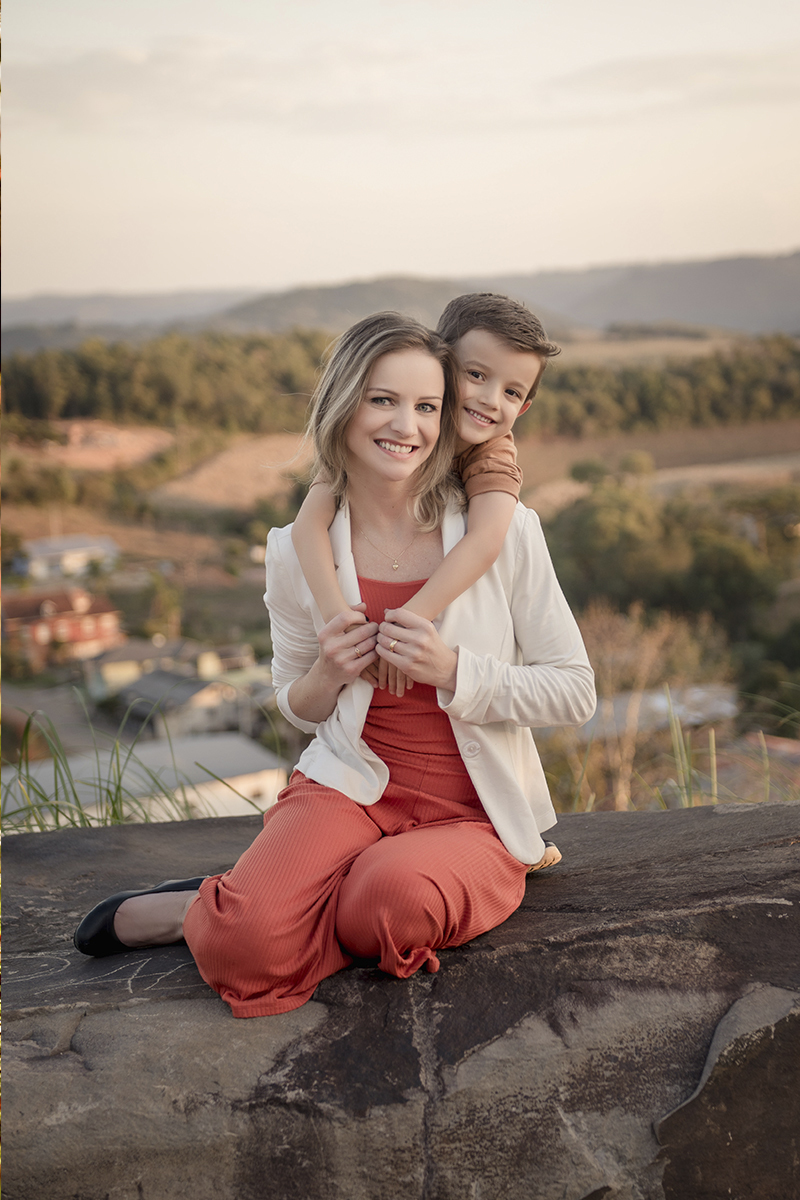 Foto de familia em caxias do sul fotografa morgana perini mae com menino nas costas roupa pessego com branco
