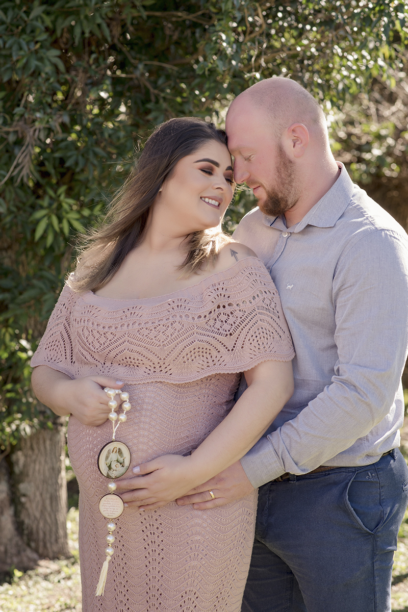 Foto de gestante em caxias do sul fotografa morgana perini gestante com terço sorrindo marido.