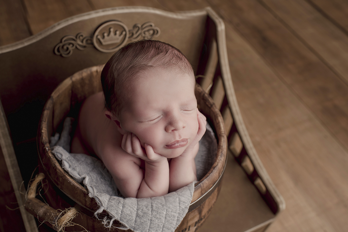 Foto newborn em caxias do sul fotografa morgana perini bebe de bruços segurando rosto sapinho