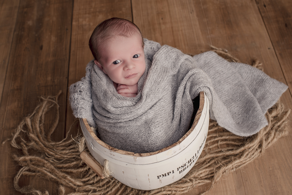 Foto newborn em caxias do sul fotografa morgana perini bebe enroladinho tecido cinza olhos abertos