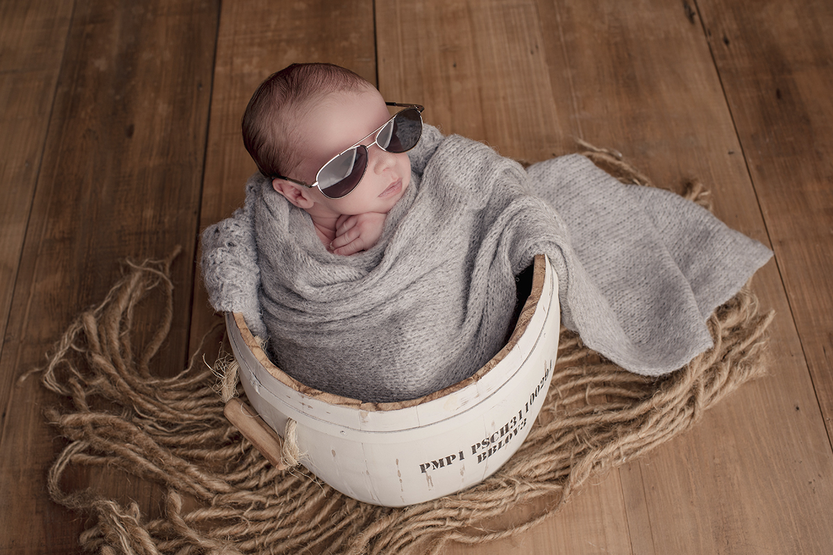 Foto newborn em caxias do sul fotografa morgana perini bebe oculos escuros ebrolado tecido cinza e marrom