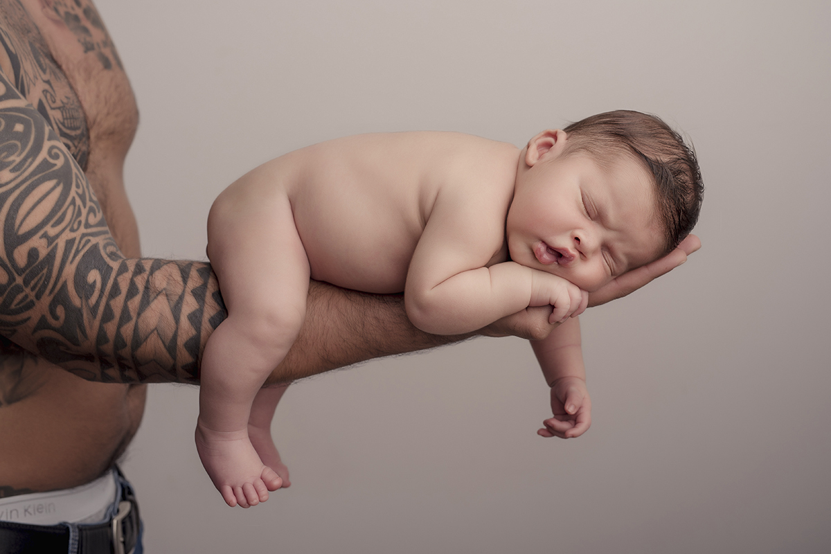 Foto newborn em caxias do sul fotografa morgana perini pai segurando bebe no braço tattoado
