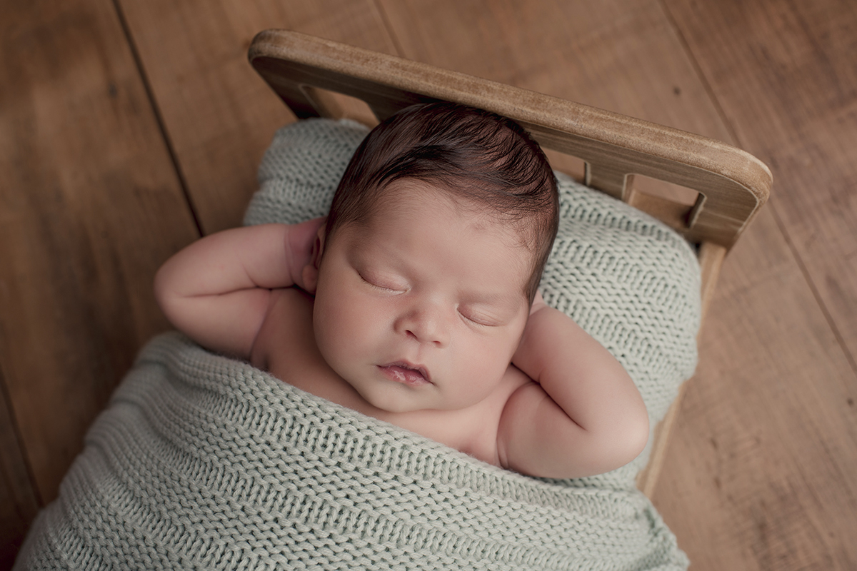 Foto newborn em caxias do sul fotografa morgana perini com braços na cabeça bebe caminha