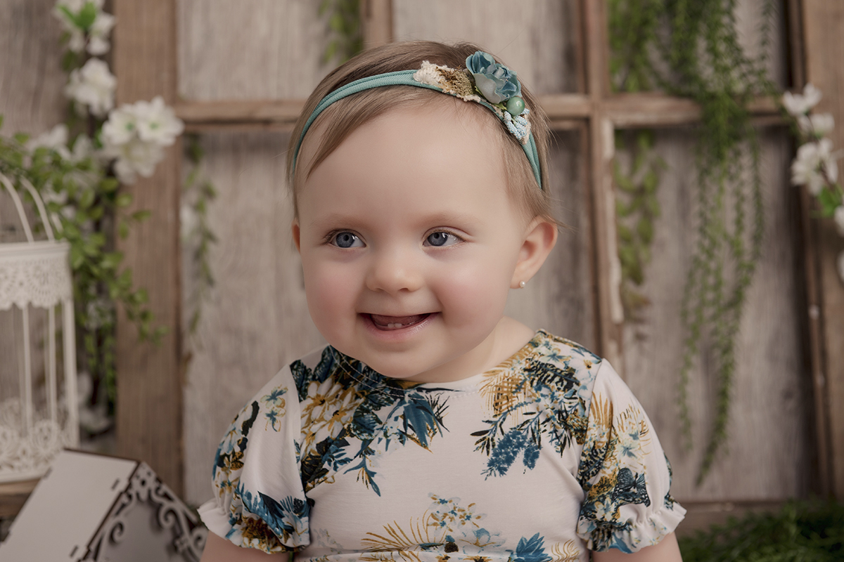 Foto de bebe em caxias do sul fotografa morgana perini bebe olhando lado vestido floral e tiara