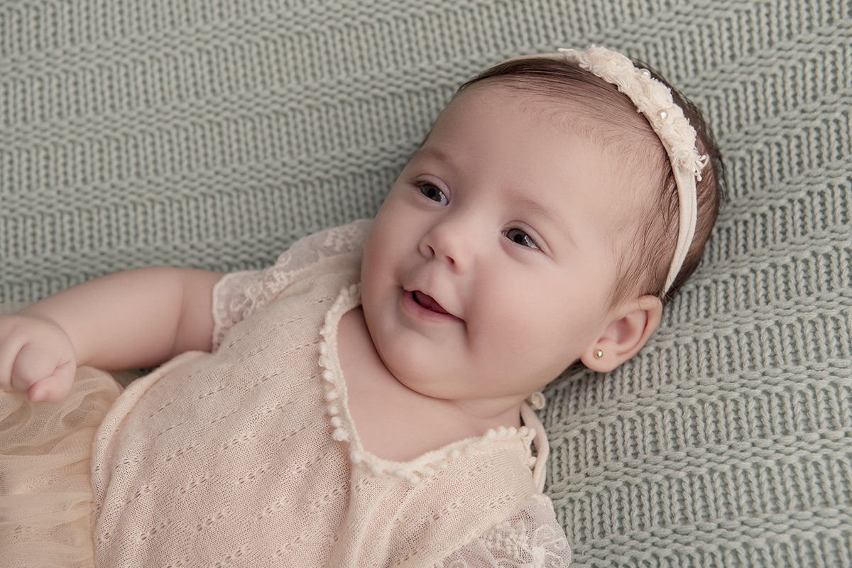 Foto de bebe em caxias do sul fotografa morgana perini menina sorrindo fundo verde
