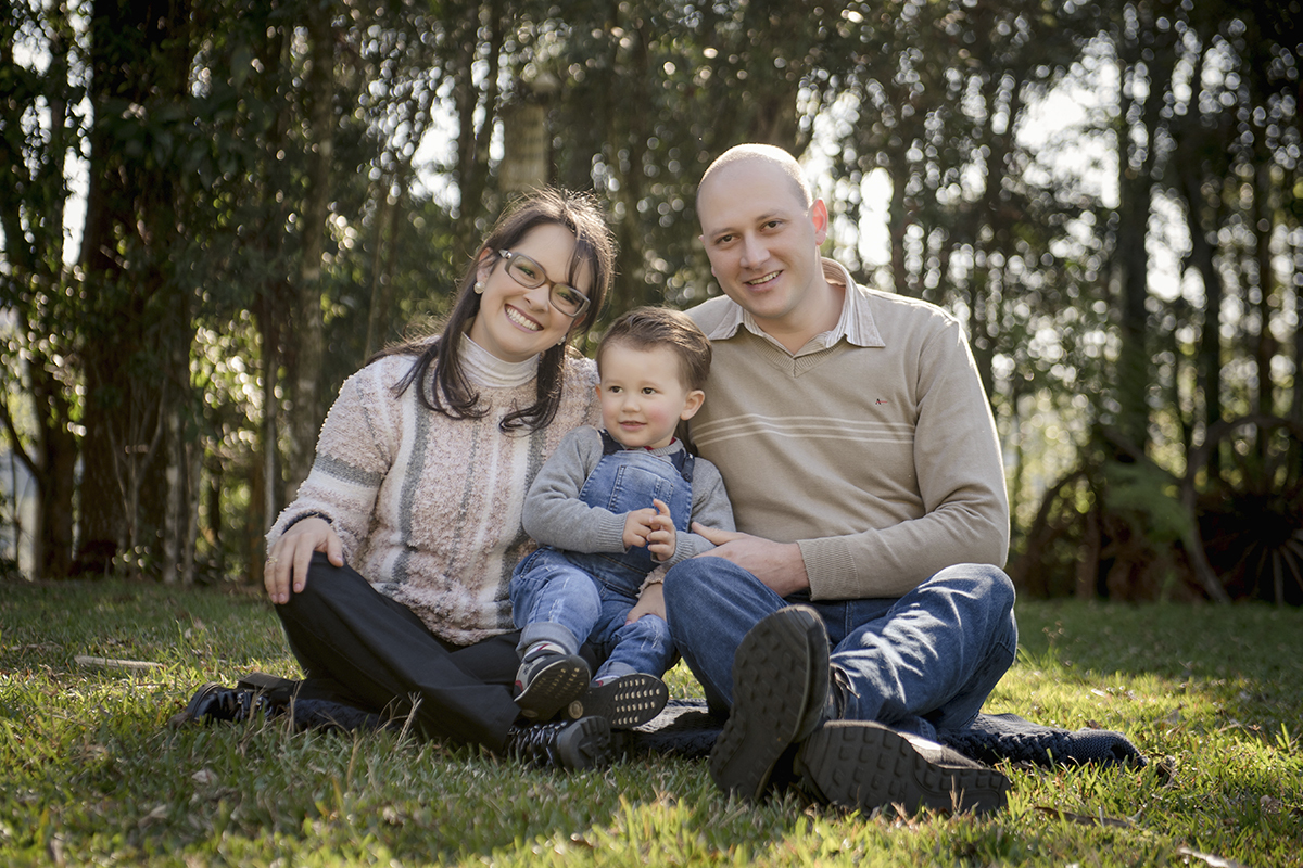 Foto de bebe em caxias do sul fotografa morgana perini pais sentados na grama com filho
