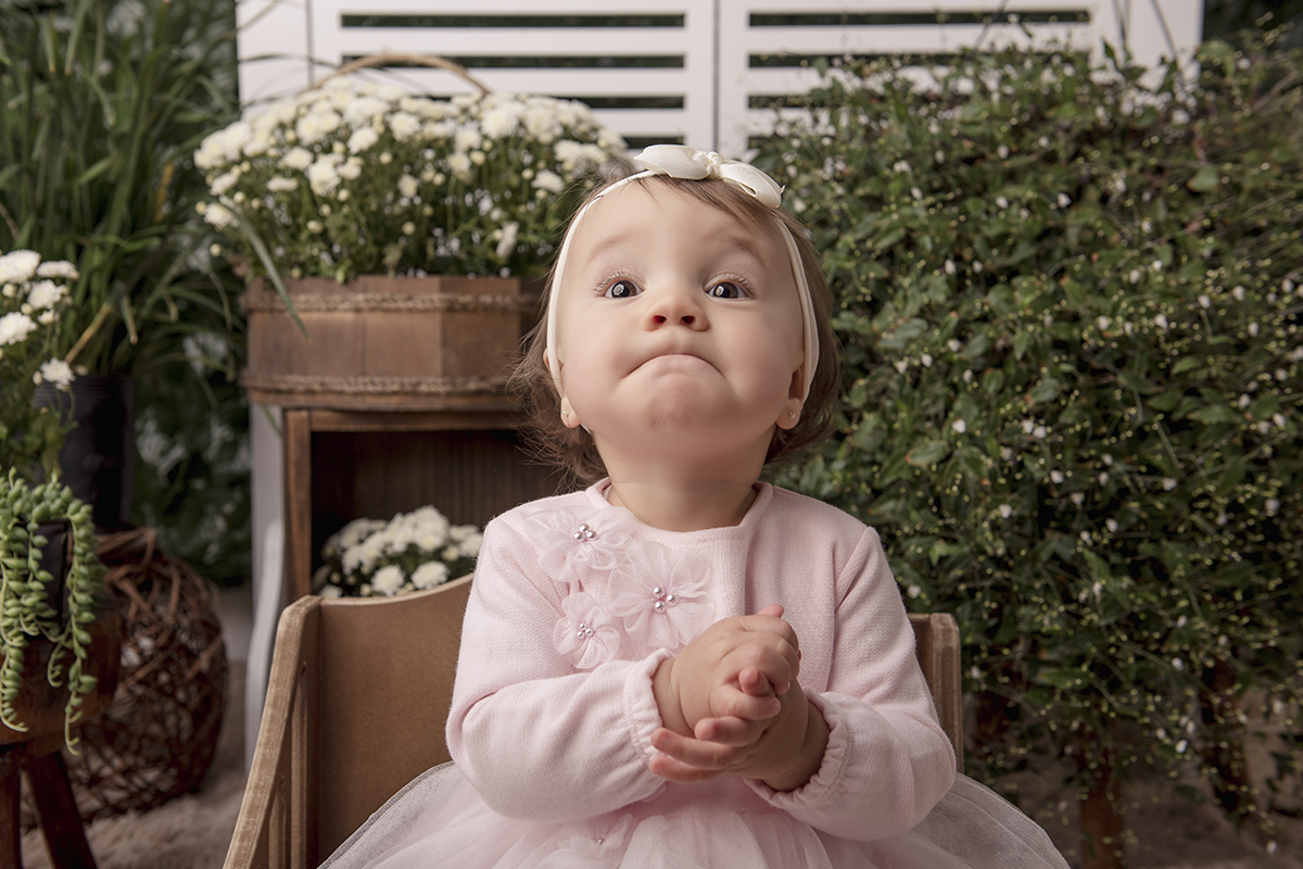 Foto de smash em caxias do sul fotografa morgana perini menina vestido rosa sentada segurando maozinhas