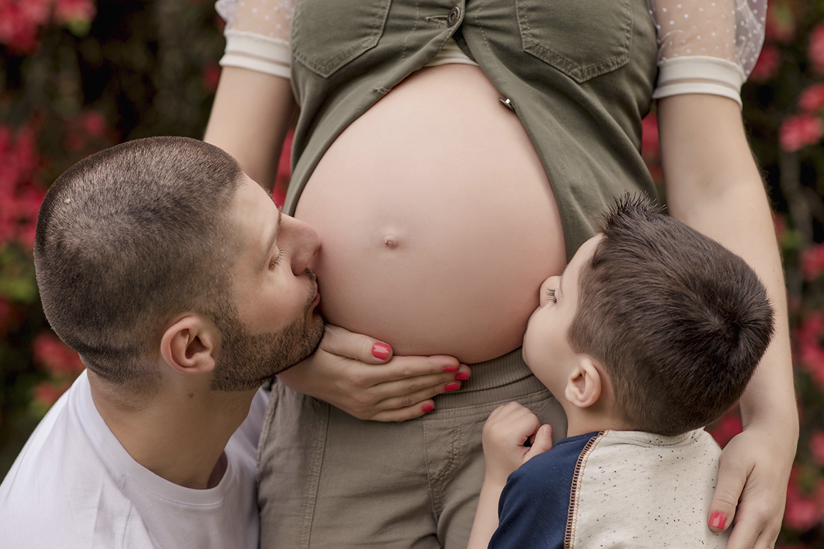 Foto de gestante em caxias do sul fotografa morgana perini pai e filho beijando barriga gestante