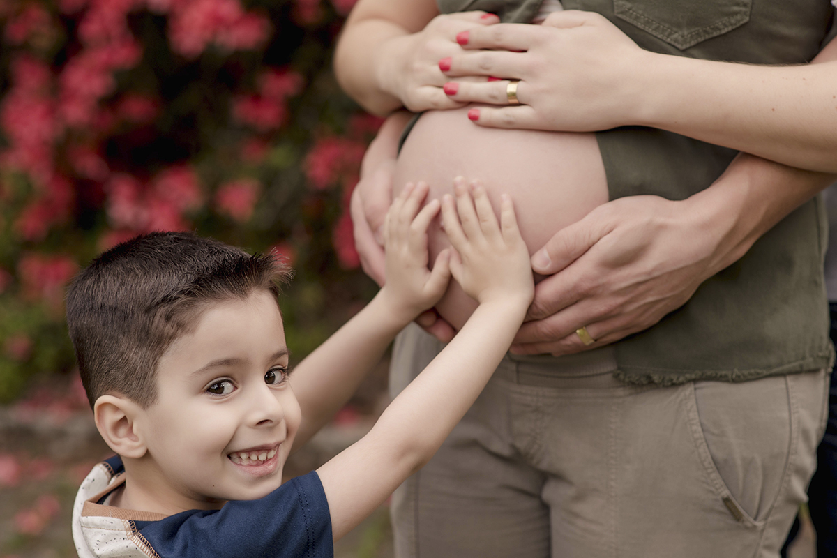 Foto de gestante em caxias do sul fotografa morgana perini irmazinho com maos na barriga sorrindo