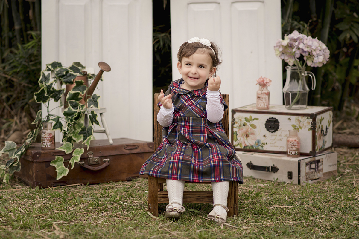 menina cadeira grama vestido xadrez