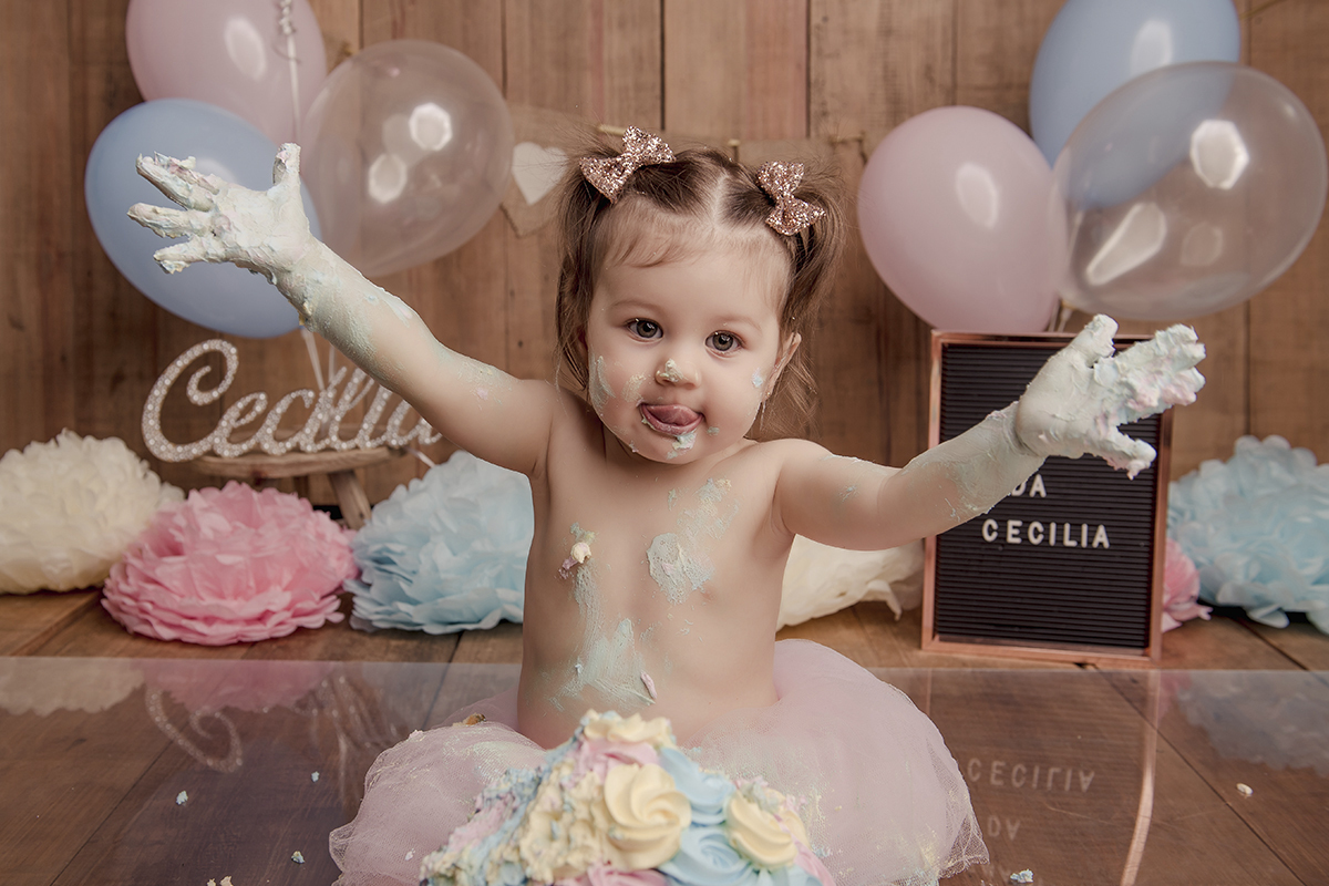 menina suja de bolo maos para cima