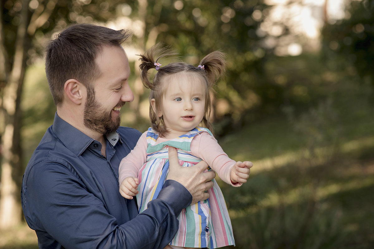 pai de azul sorrindo menina loira vestido listrado