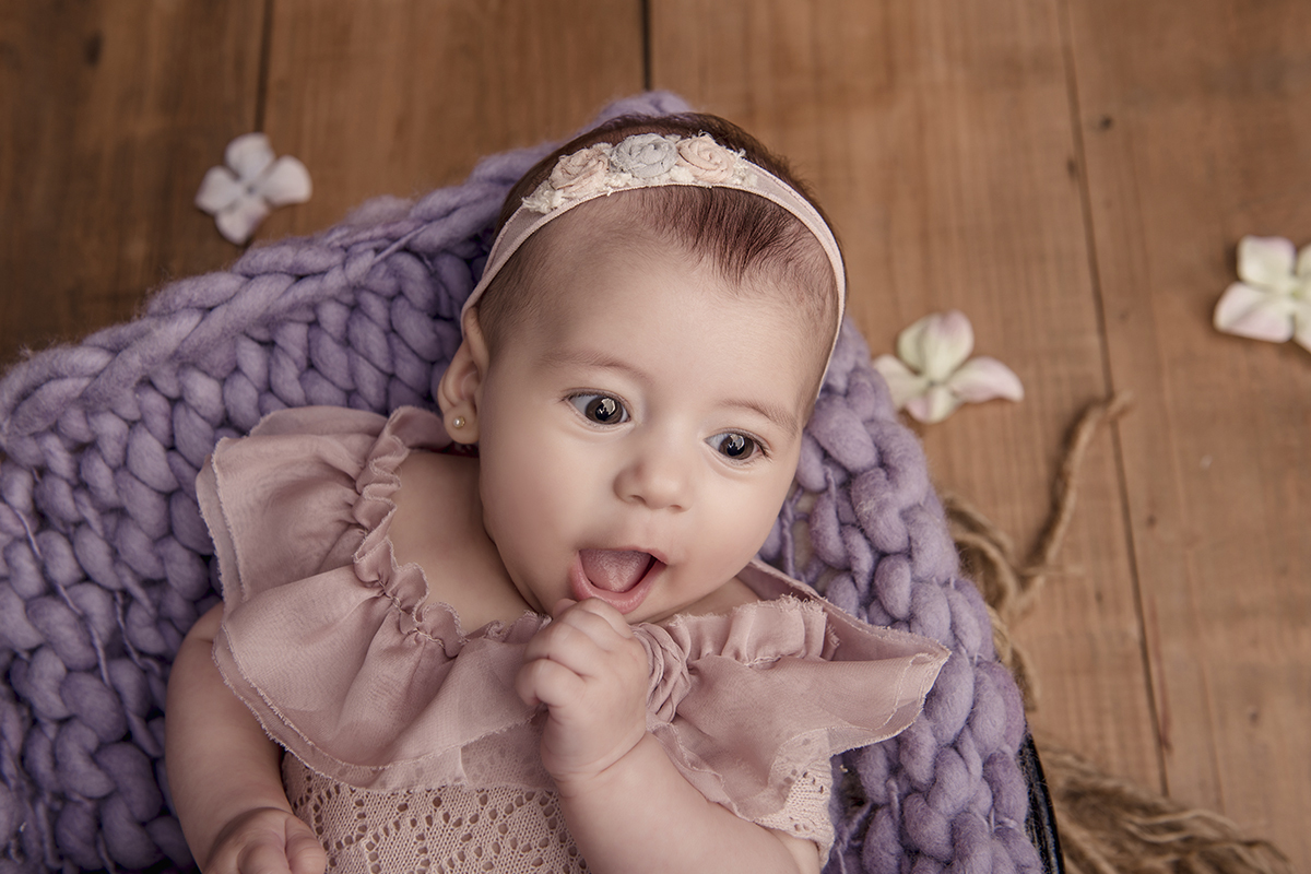 menina sorrindo tecidos roxos