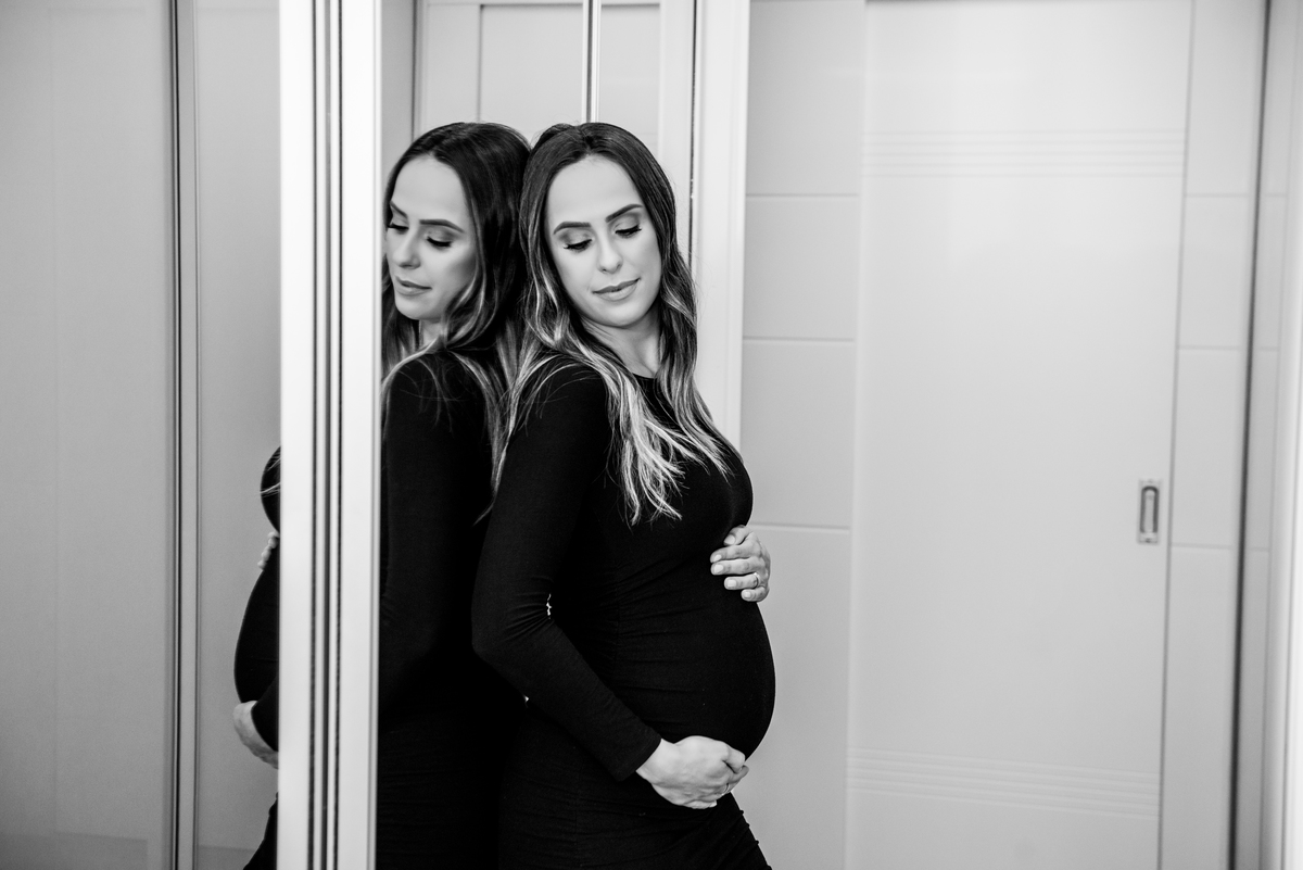 gestante vestido preto olhando para baixo
