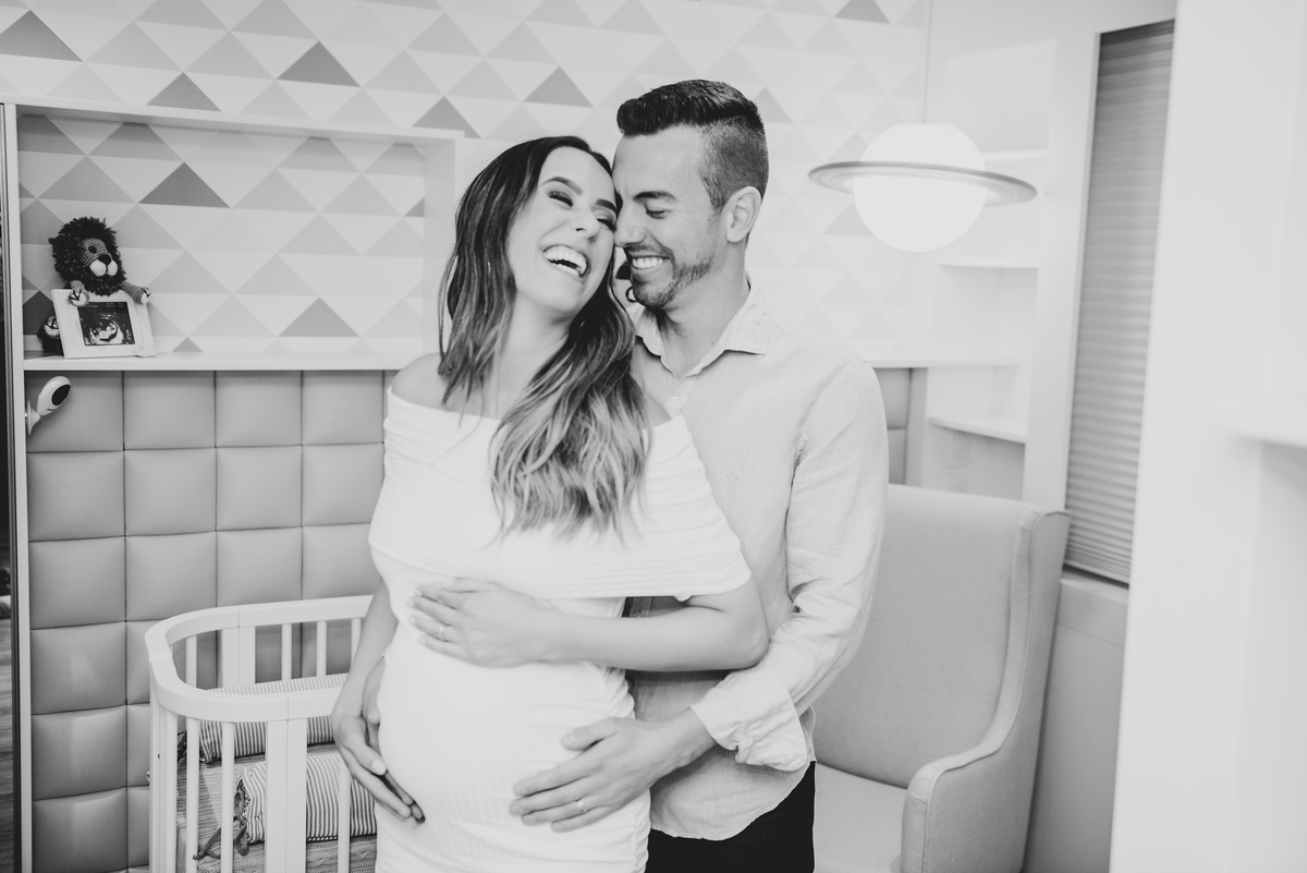 casal sorrindo quarto do bebe