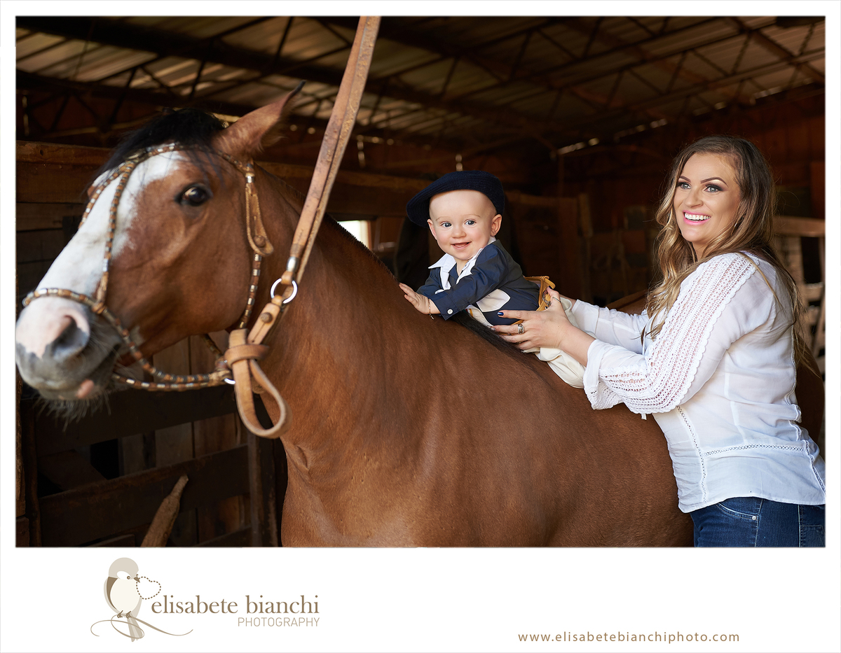 Ensaio 9 meses de bebê em externa sessão fotográfica de acompanhamento trimestral numa fazenda de campo, com cavalos e ovelhas Caxias do Sul montaria de gaudério