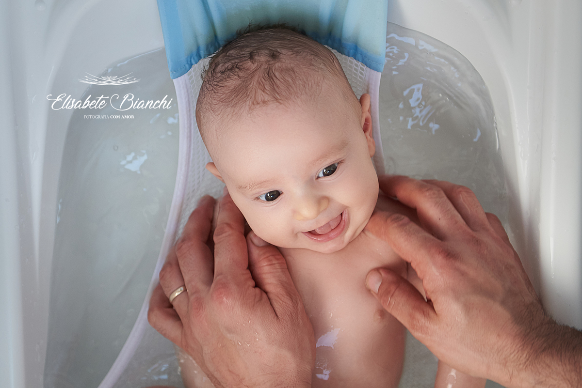 Bebê de 3 meses feliz e sorridente, no banho de banheira, em ensaio de acompanhamento fotográfico, em São Marcos, RS.