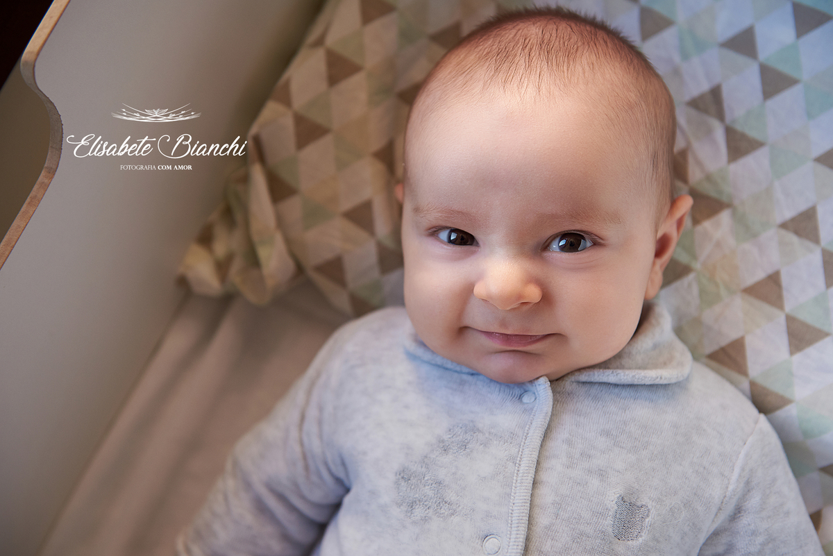3 meses de vida de um bebê sorridente, deitado em seu bercinho, em ensaio de fotos no domicílio, em São Marcos, RS.