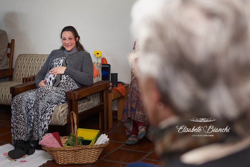 Gestante ouvindo o relato de maternagem, de sua tia, em chá de bênçãos, em Caxias do Sul.