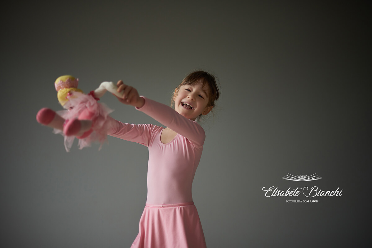Menina bailarina dançando e girando com boneca, em ensaio de fotos em Caxias do Sul.