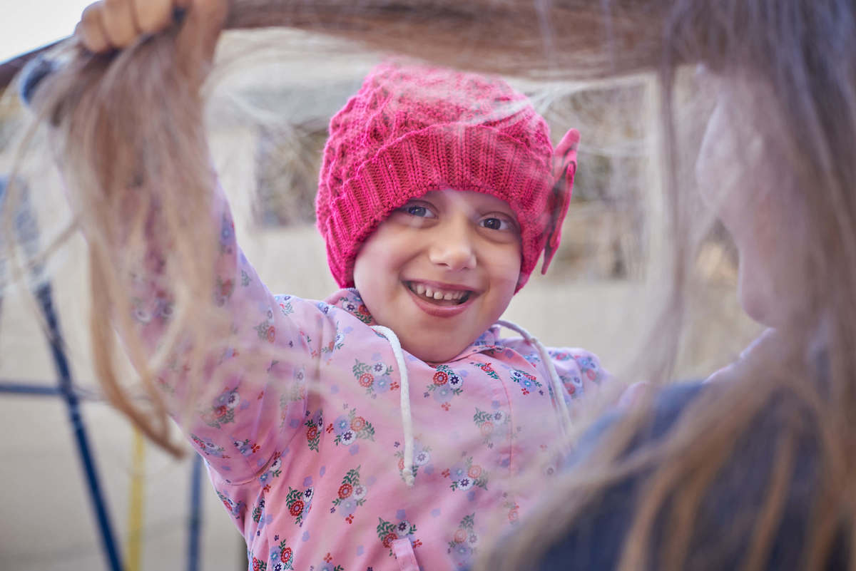 Menina com câncer brincando com os cabelos da irmã, em ensaio fotográfico em Caxias do Sul - RS.