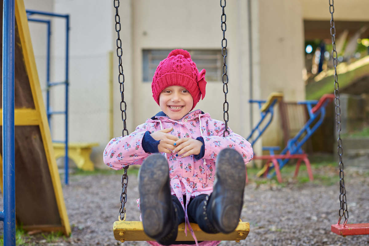 Menina com câncer brincando no balanço do parquinho, em Caxias do Sul - RS.