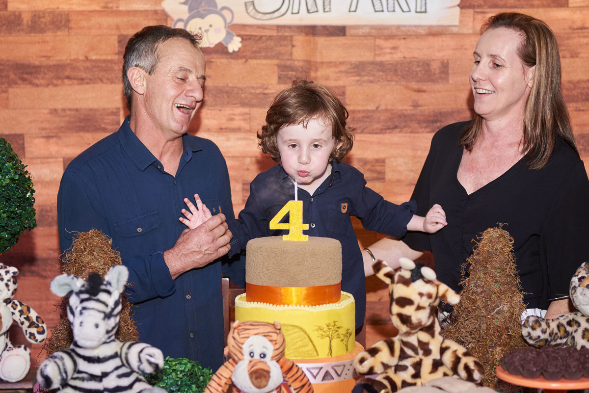 Aniversariante assoprando a velinha na  festa infantil de 4 anos, tema safari, na Hakuna, Caxias do Sul, RS.