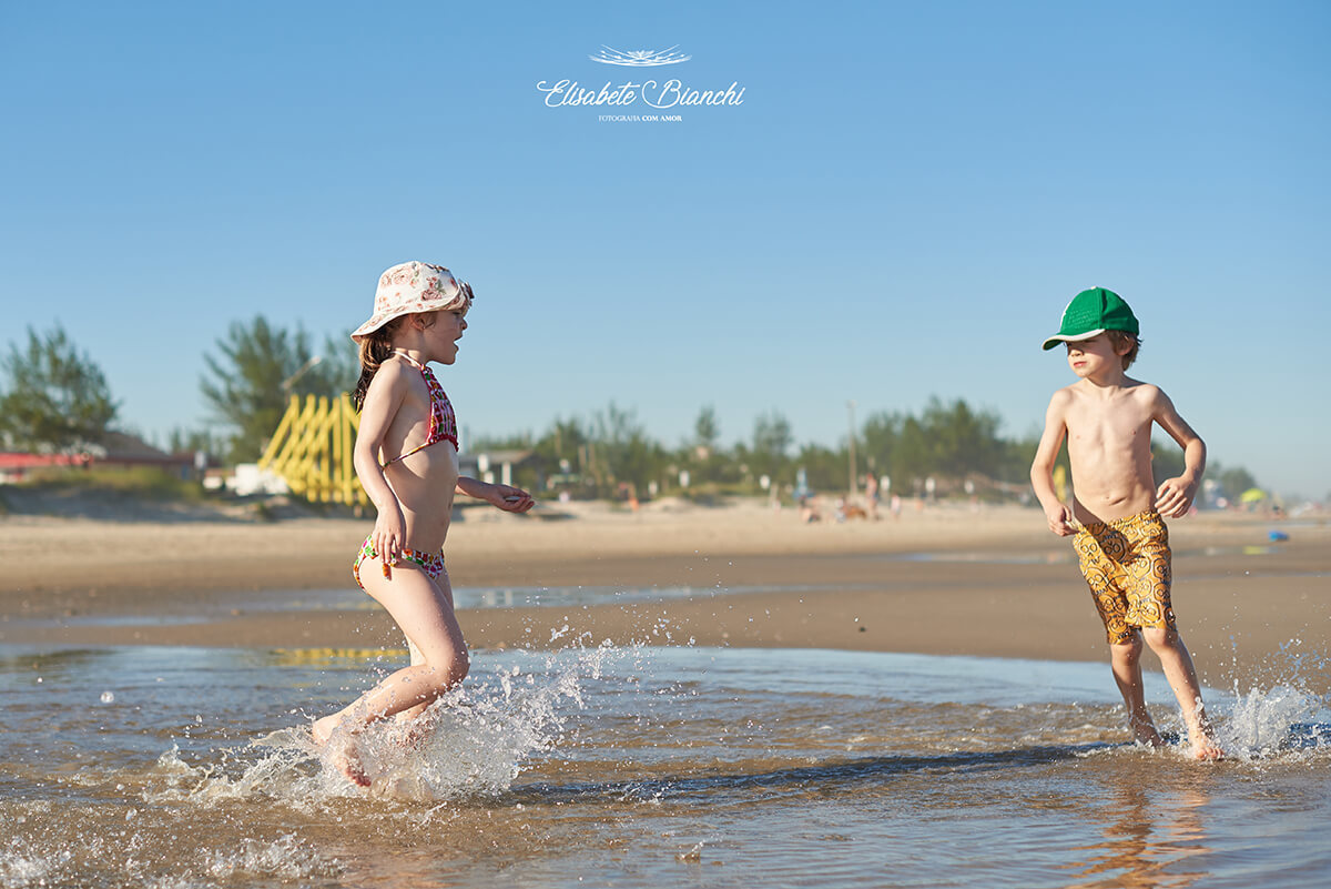 Crianças correndo na beira do mar, em Bella Torres, Santa Catarina.