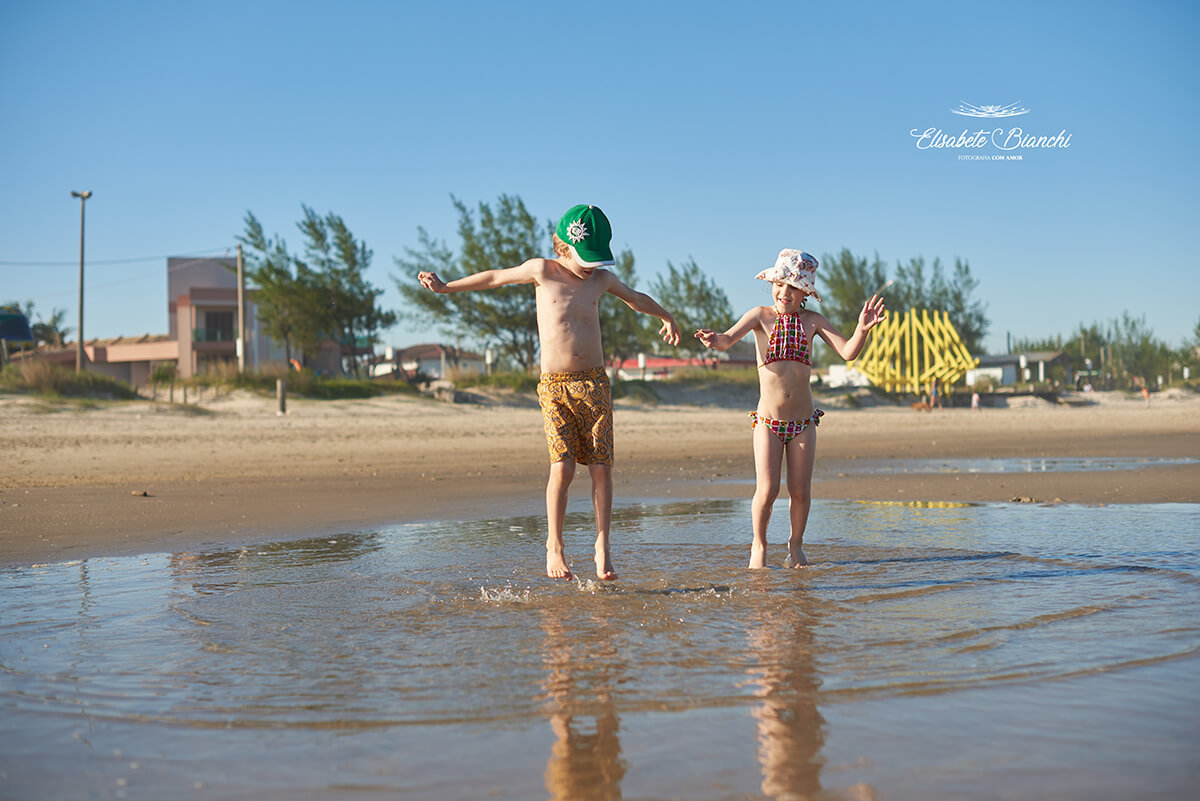 Crianças pulando na água do mar em Bella Torres, Santa Catarina.