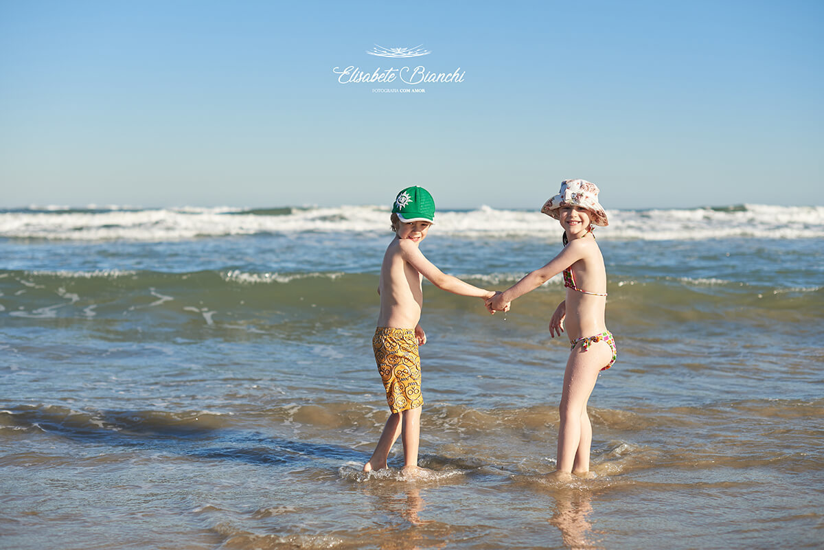 Crianças de mãos dadas, na beira do mar de Bella Torres - SC.