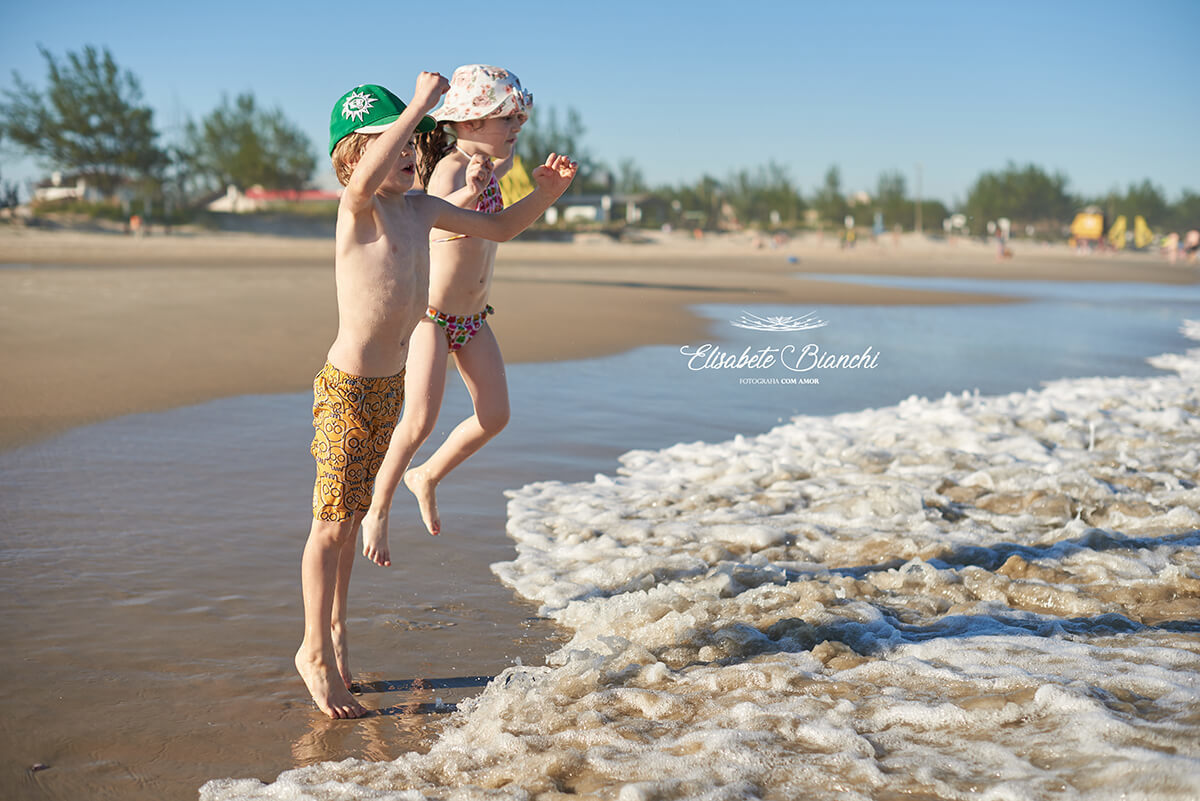Crianças pulando onda na beira do mar de Bella Torres - SC.