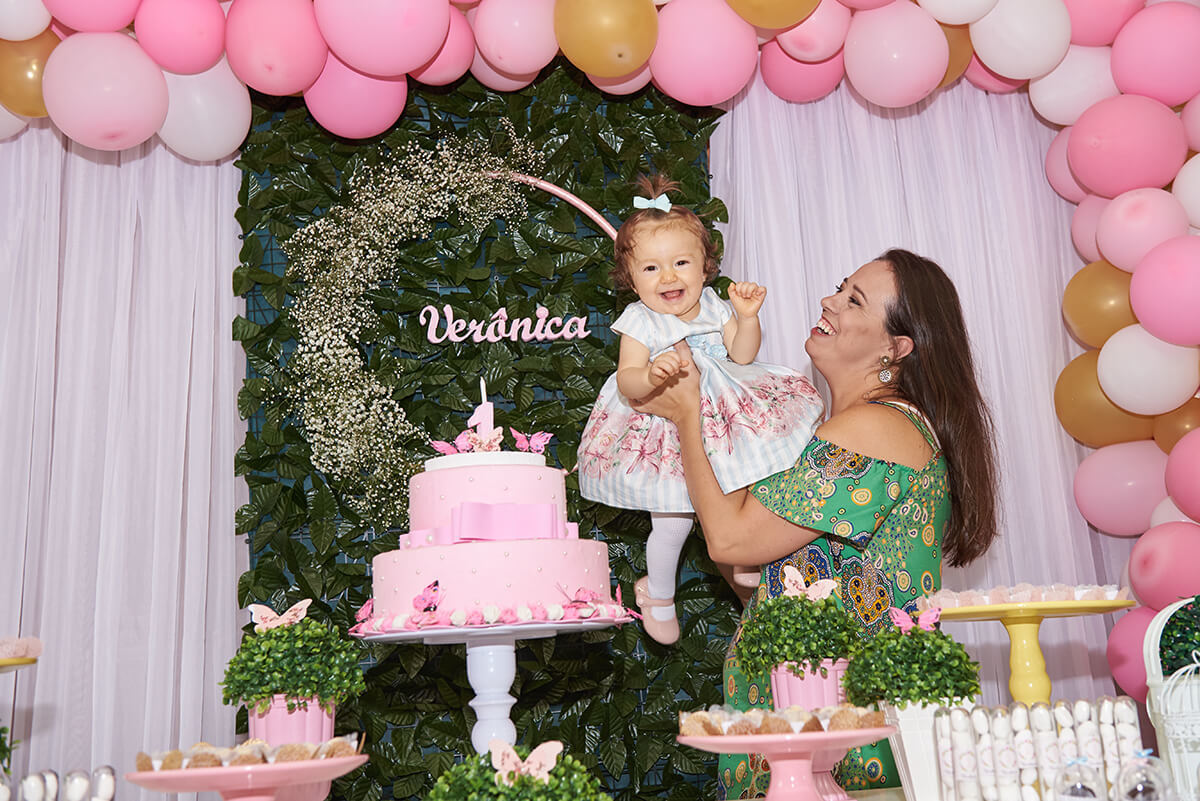 Mamãe erguendo a filha de 1 ano de idade em sua festinha de aniversário, em Caxias do Sul - RS.