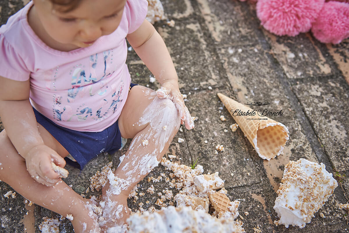 Bebê sujo de glacê durante ensaio smash the cake, na praia Bella Torres,  Balneário de Passo de Torres - SC.