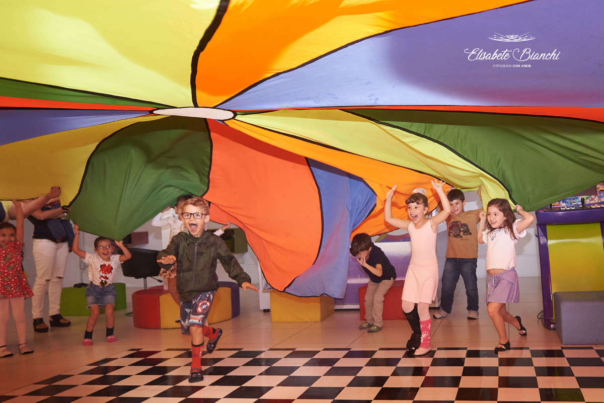 Aniversariante brincando sob uma lona de balão com seus amigos, na festa de aniversário de 6 anos, na casa de festas Gato & Topo, em Caxias do Sul - RS.