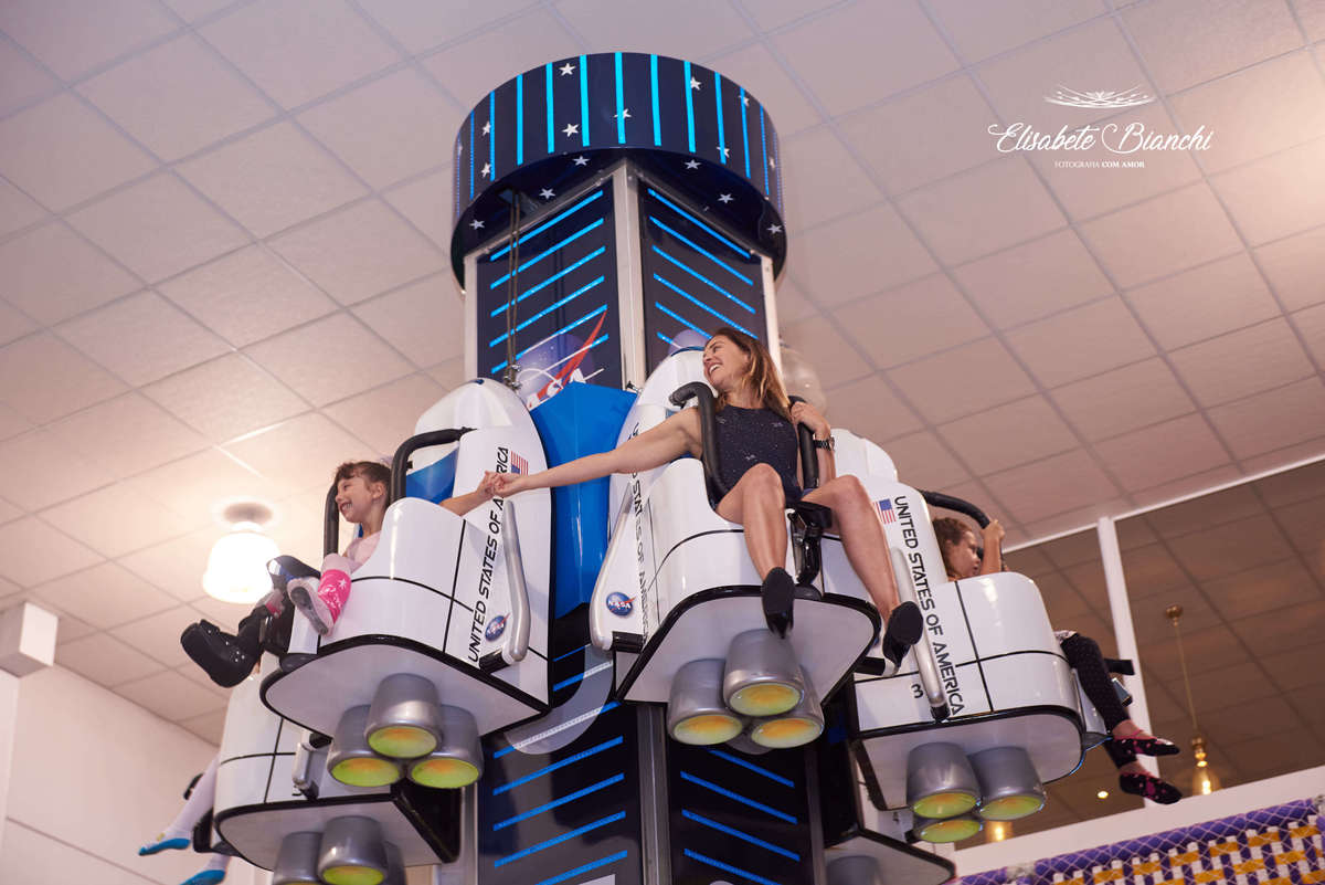 Aniversariante brincando no elevador que cai, segurando a mão de sua mãe, na festa de aniversário de 6 anos, na casa de festas Gato & Topo, em Caxias do Sul - RS.