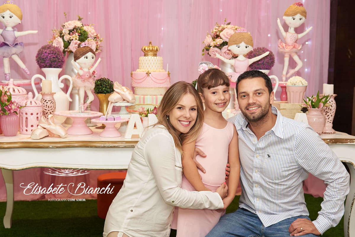Aniversariante com os dindos em frente à mesa principal da festa infantil de 6 anos decorada no tema bailarina, na casa de festas Gato & Topo, em Caxias do Sul - RS.