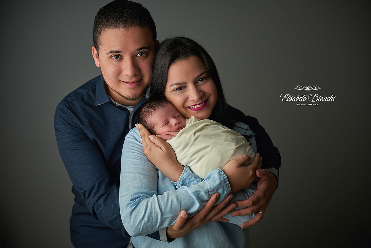 Bebê recém-nascido com seus pais, enroladinho, no ensaio newborn, em Caxias do Sul - RS.