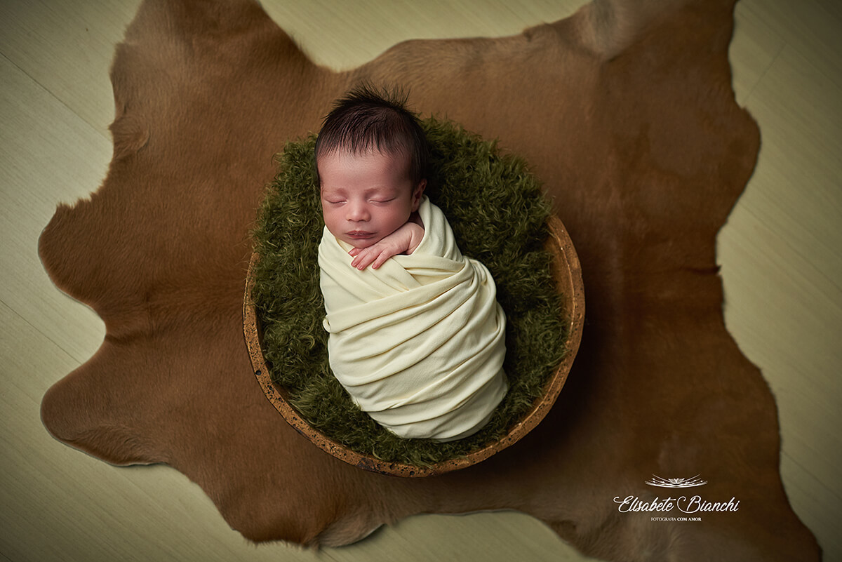 Bebê recém-nascido dentro de uma gamela, enroladinho, no ensaio newborn, em Caxias do Sul - RS.