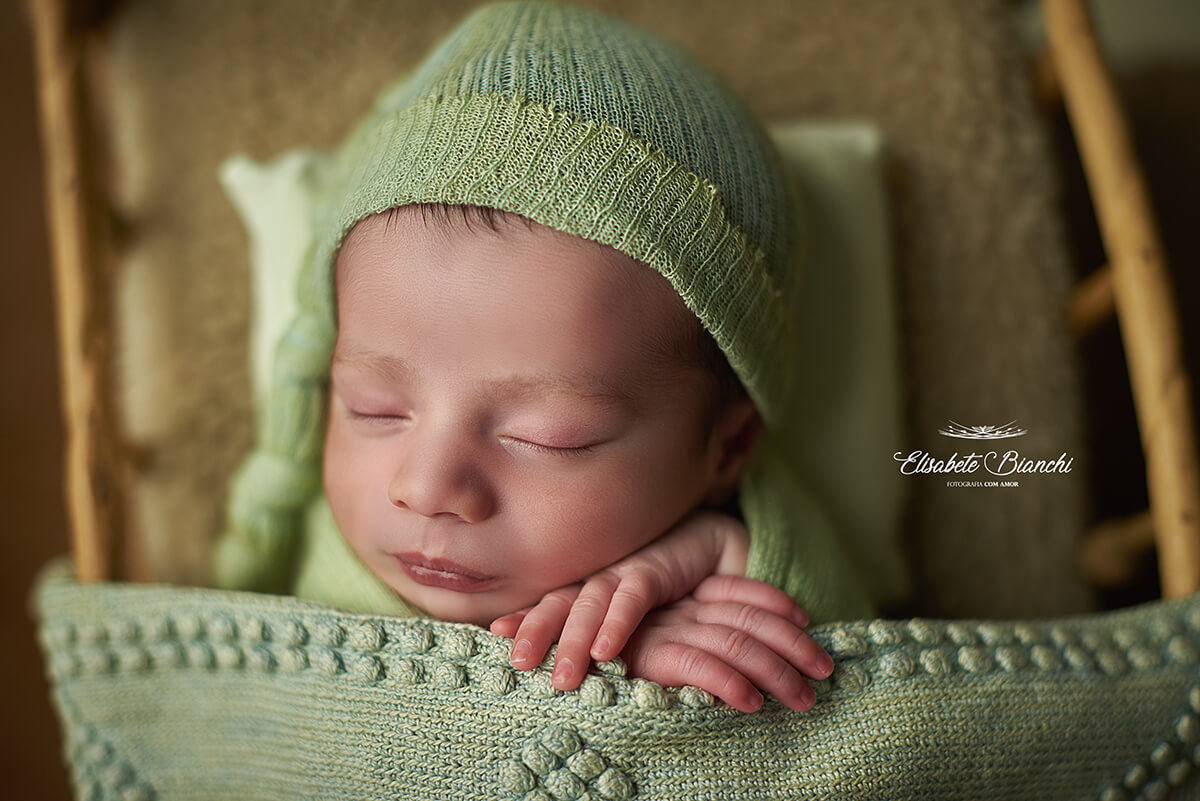 Bebê recém-nascido dormindo na caminha, enroladinho, no ensaio newborn, em Caxias do Sul - RS.
