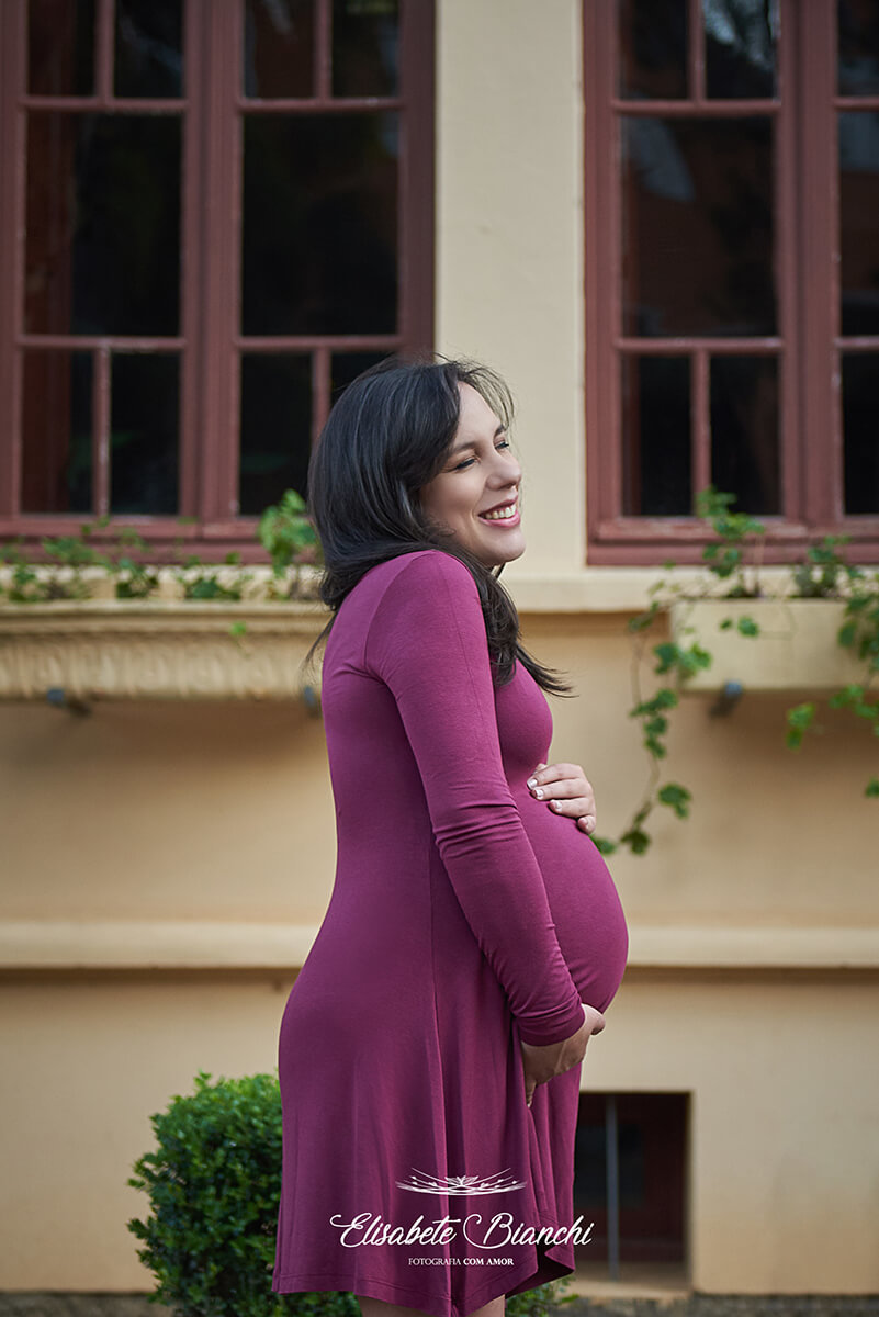 Gestante sorrindo e cuidando do bebê na barriga, em ensaio fotográfico, Caxias do Sul.