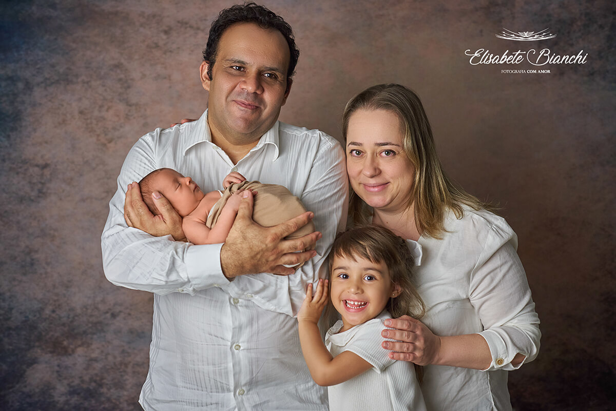 Família com seus dois filhos, sendo um recém-nascido, no ensaio newborn, em Caxias do Sul.